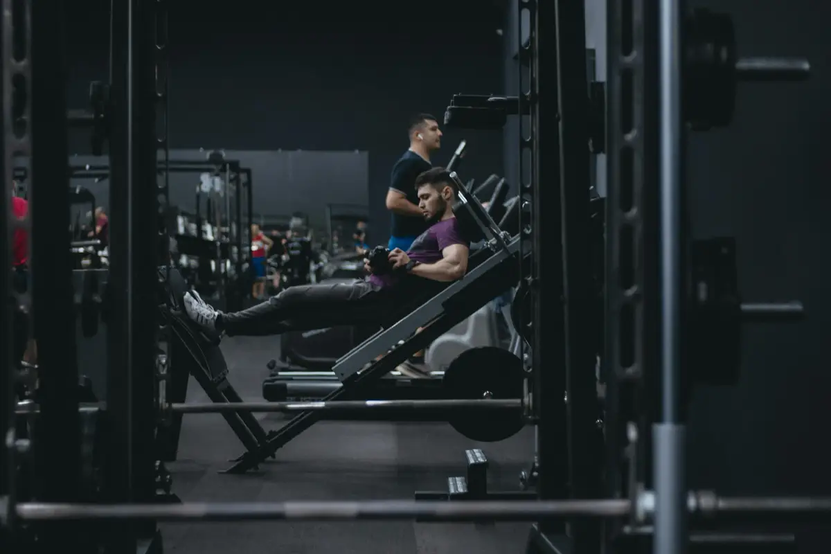 Man performing a leg press exercise on a machine at the gym, focusing on lower body strength